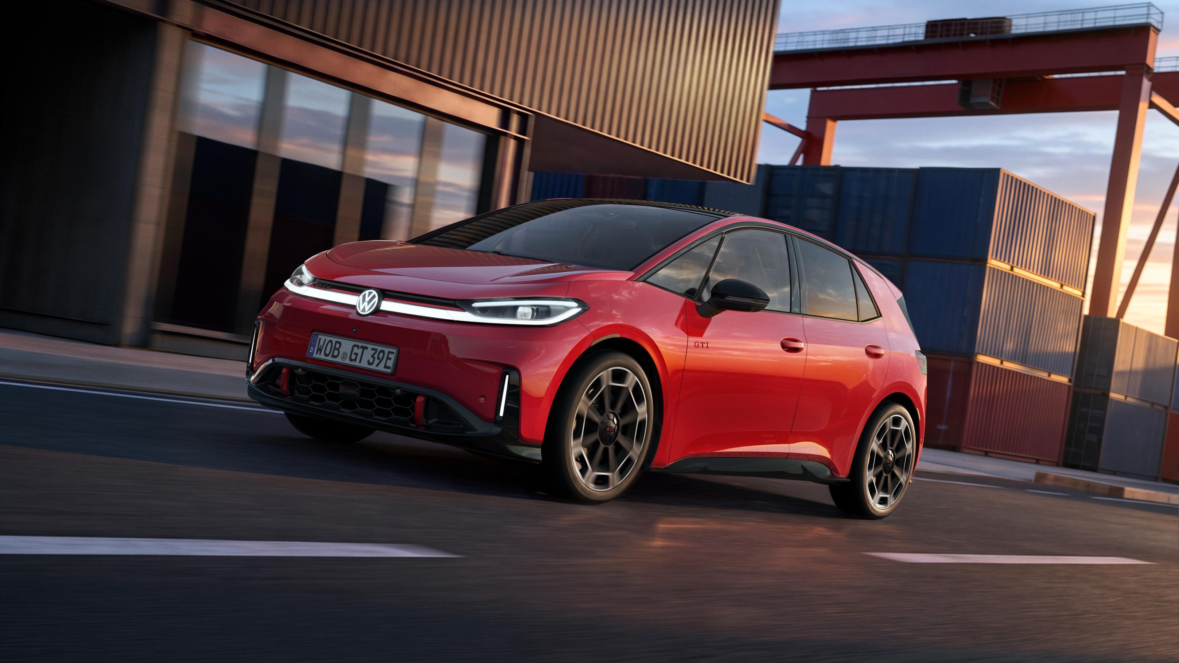 [AI-modified] – Červený VW ID.3 GTI projíždí kolem přístavní budovy se zapnutými světlomety a rozsvíceným logem.
