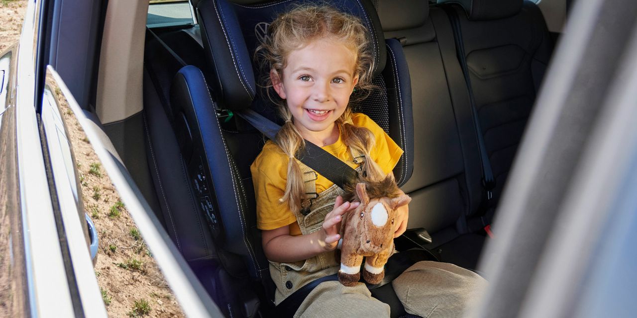 Ein Mädchen sitzt in einem Volkswagen Kindersitz