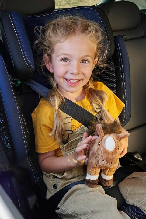 Ein Mädchen sitzt in einem Volkswagen Kindersitz