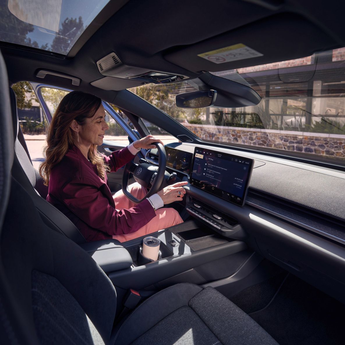 Eine Frau wählt auf dem Center-Display eines VW ID.3 Neo eine Online-Funktion aus