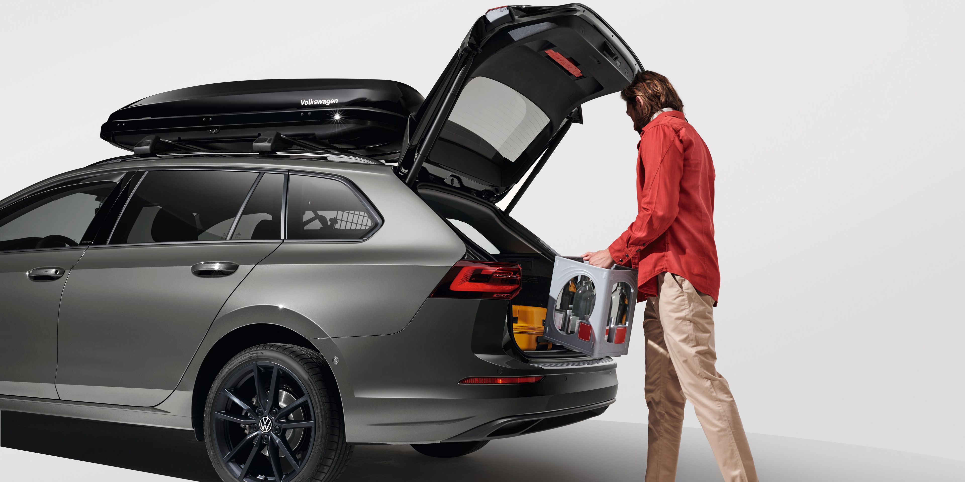 Ein Mann belädt den Kofferraum eines Volkswagen Golf Variant