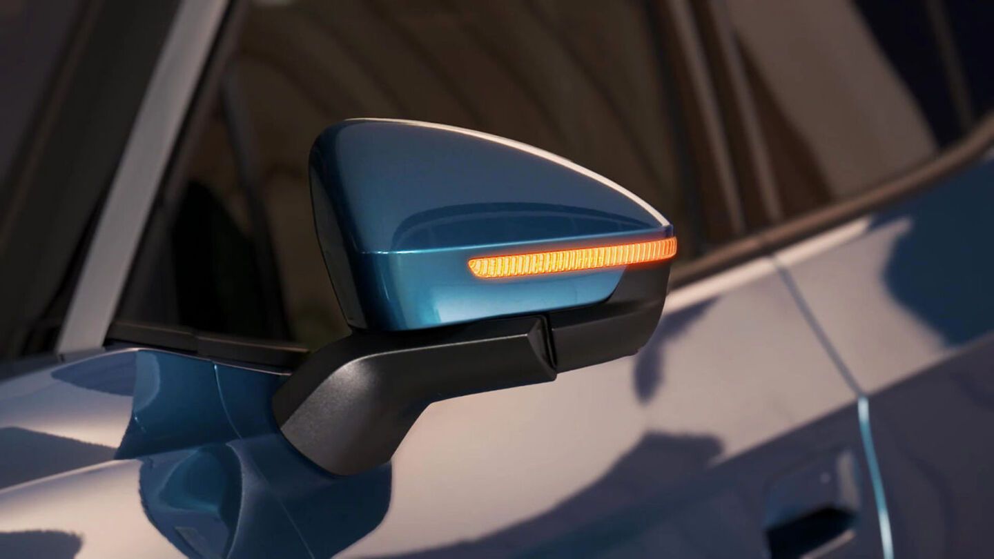 Der Seitenspiegel eines blauen ID.4 mit aktiviertem Warnblinker.