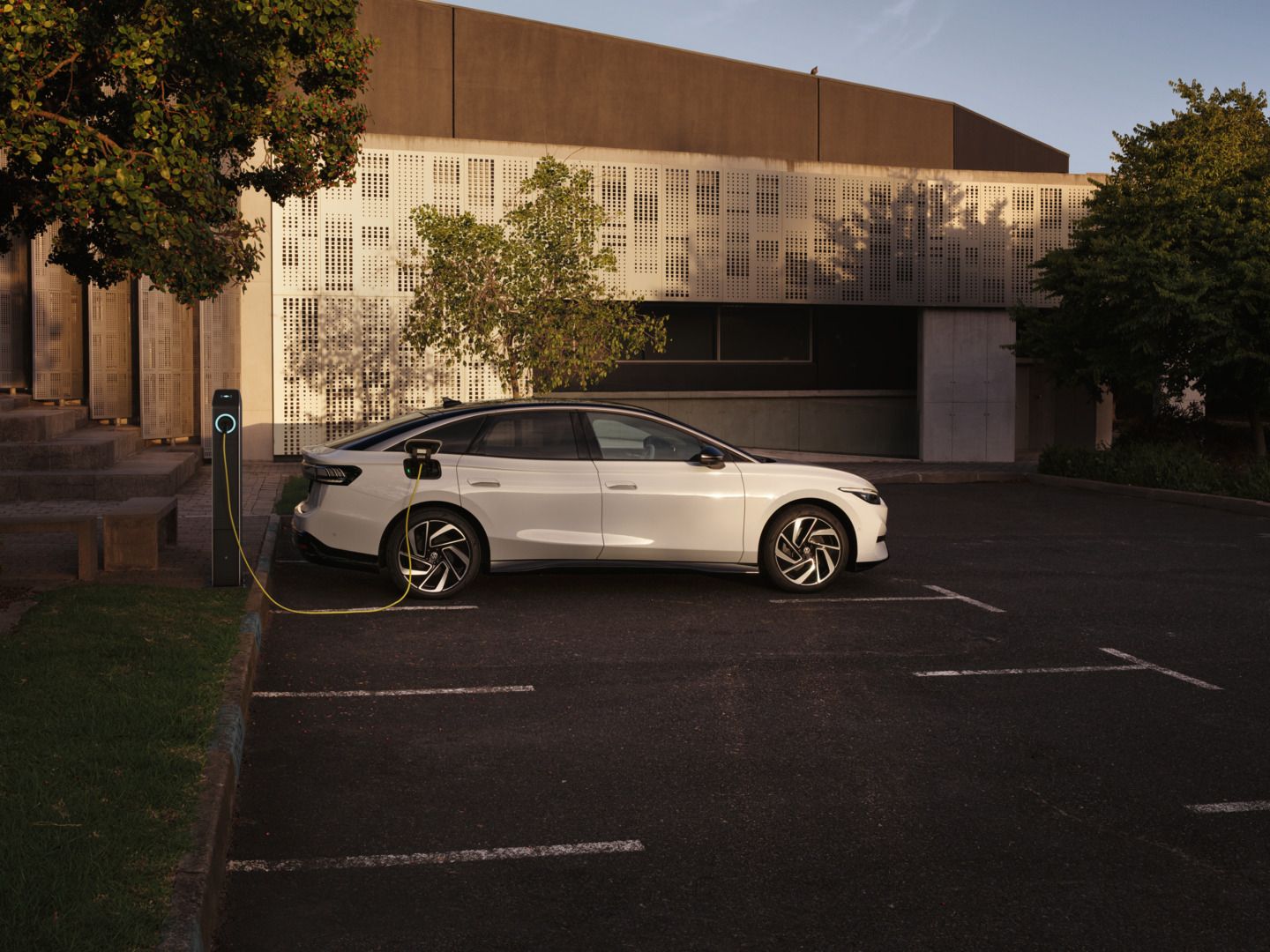 Ein weißer VW ID.7 Pro wird an einer Ladestation geladen.