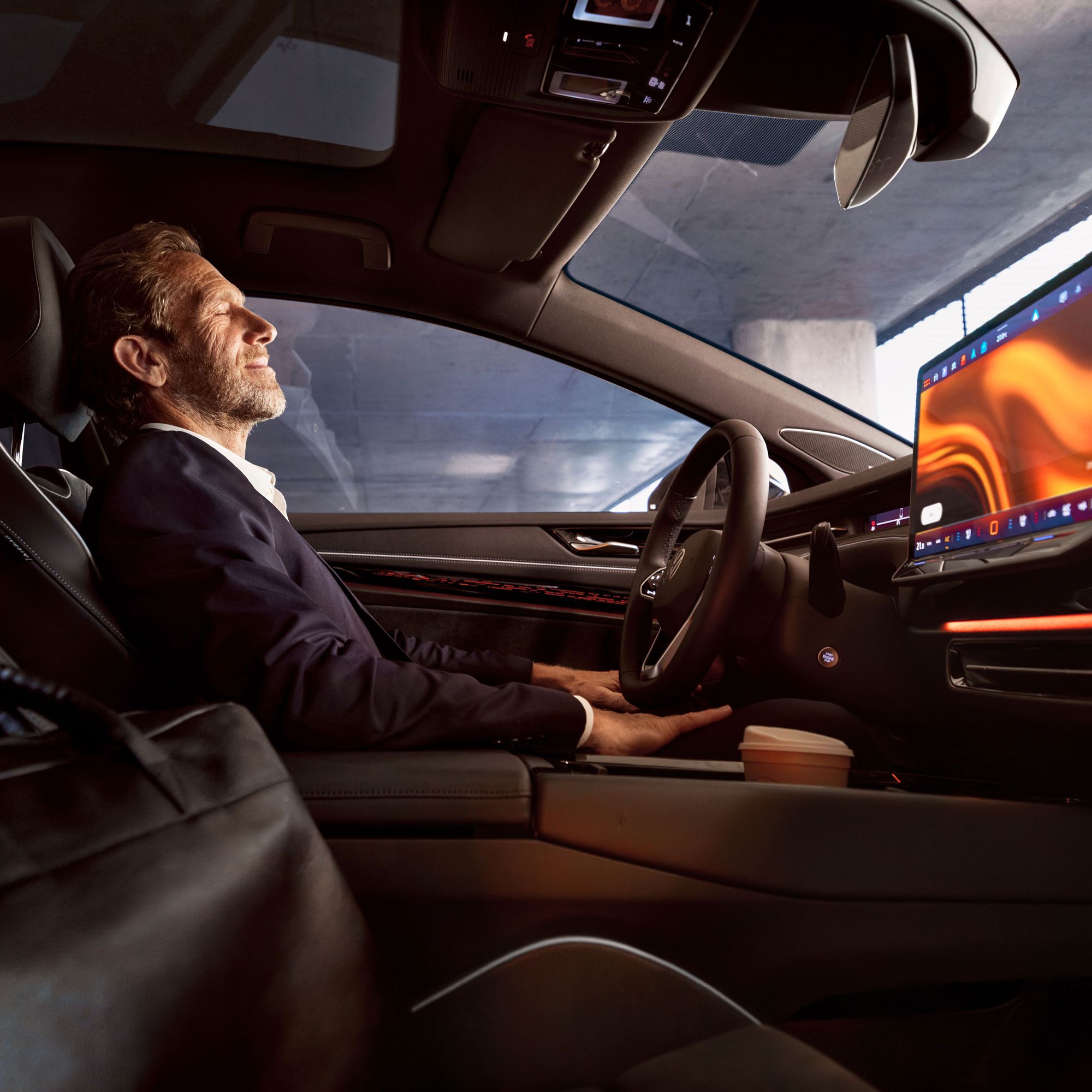 Ein Mann entspannt sich in seinem geparkten VW ID.7