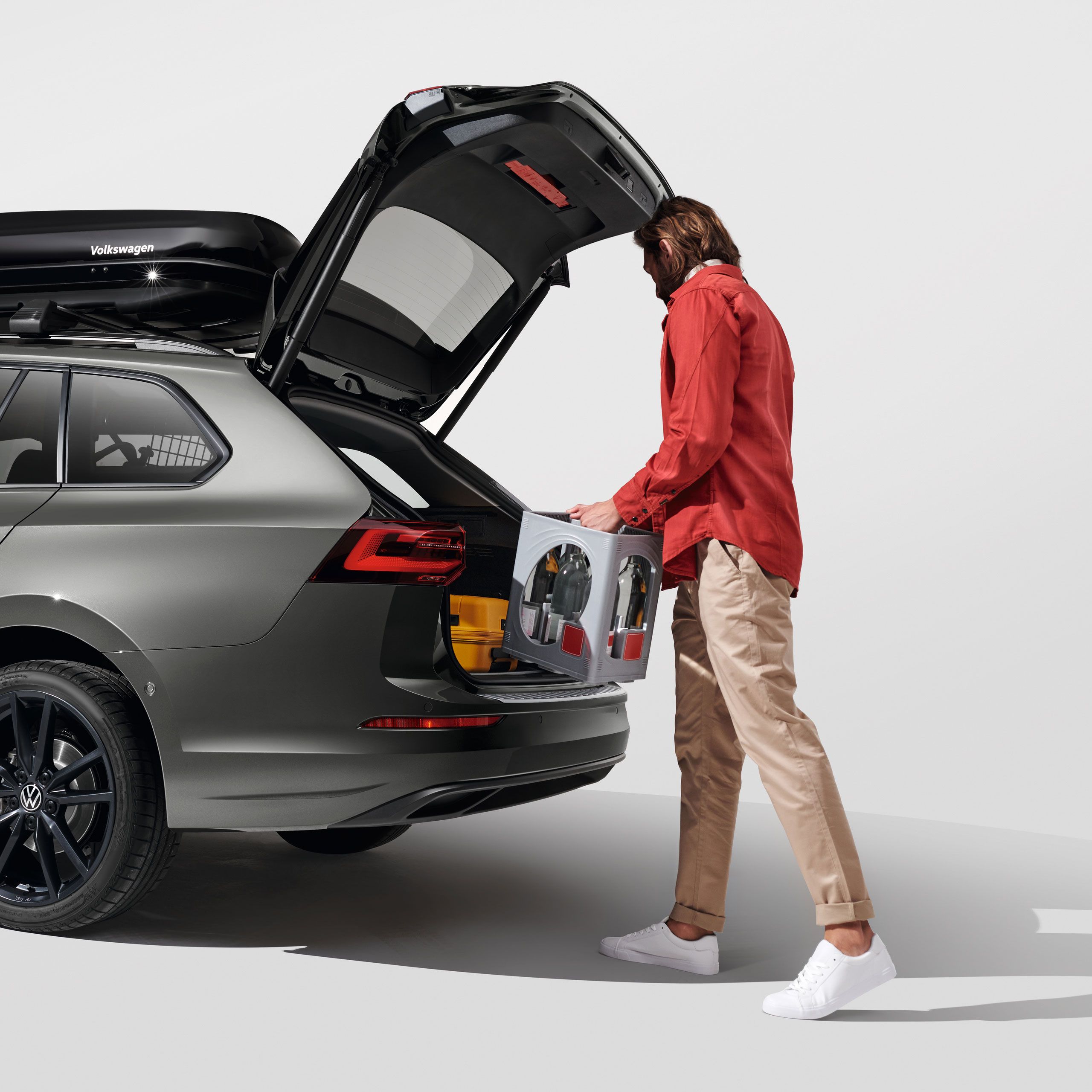 Ein Mann belädt den Kofferraum eines Volkswagen Golf Variant