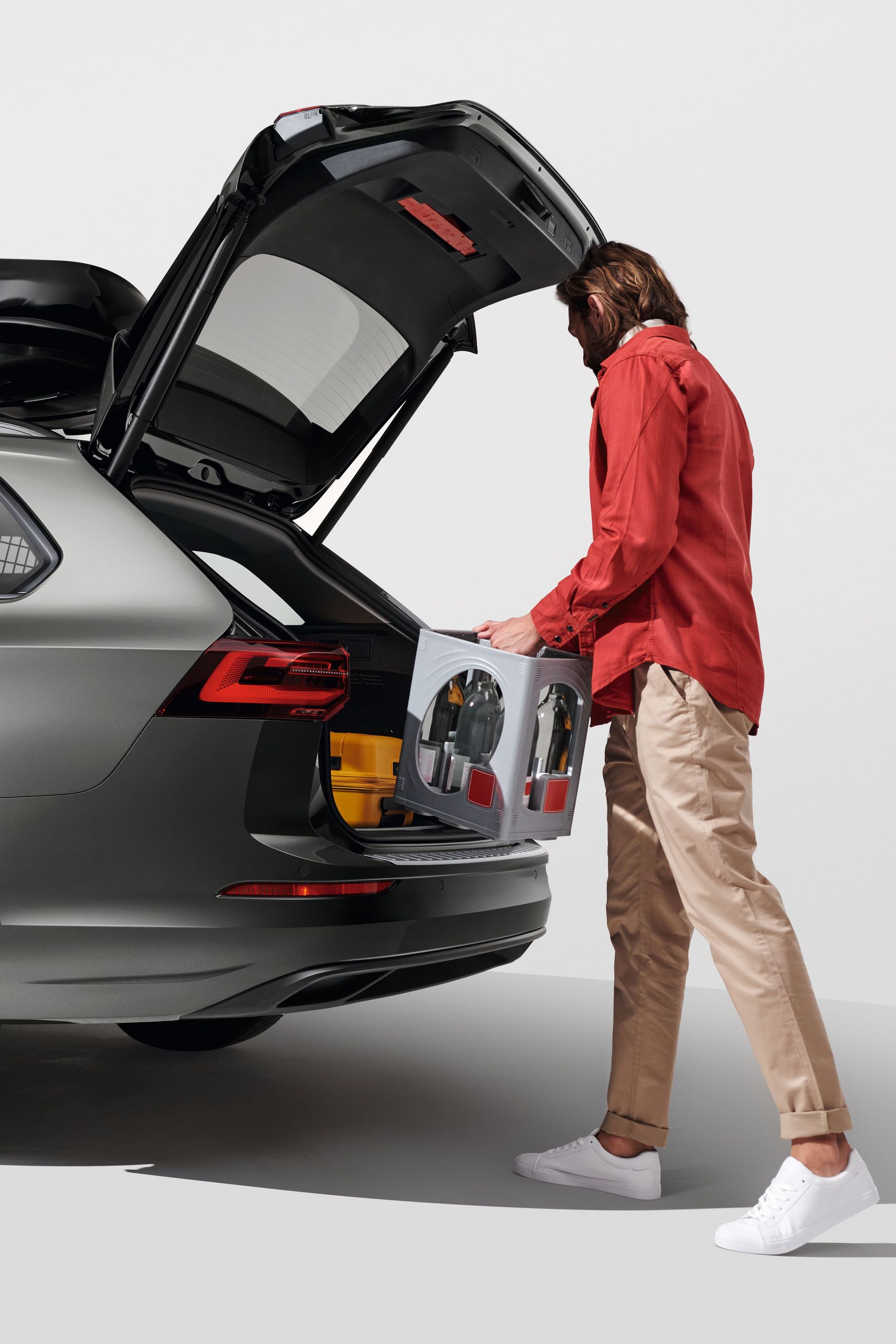 Ein Mann belädt den Kofferraum eines Volkswagen Golf Variant