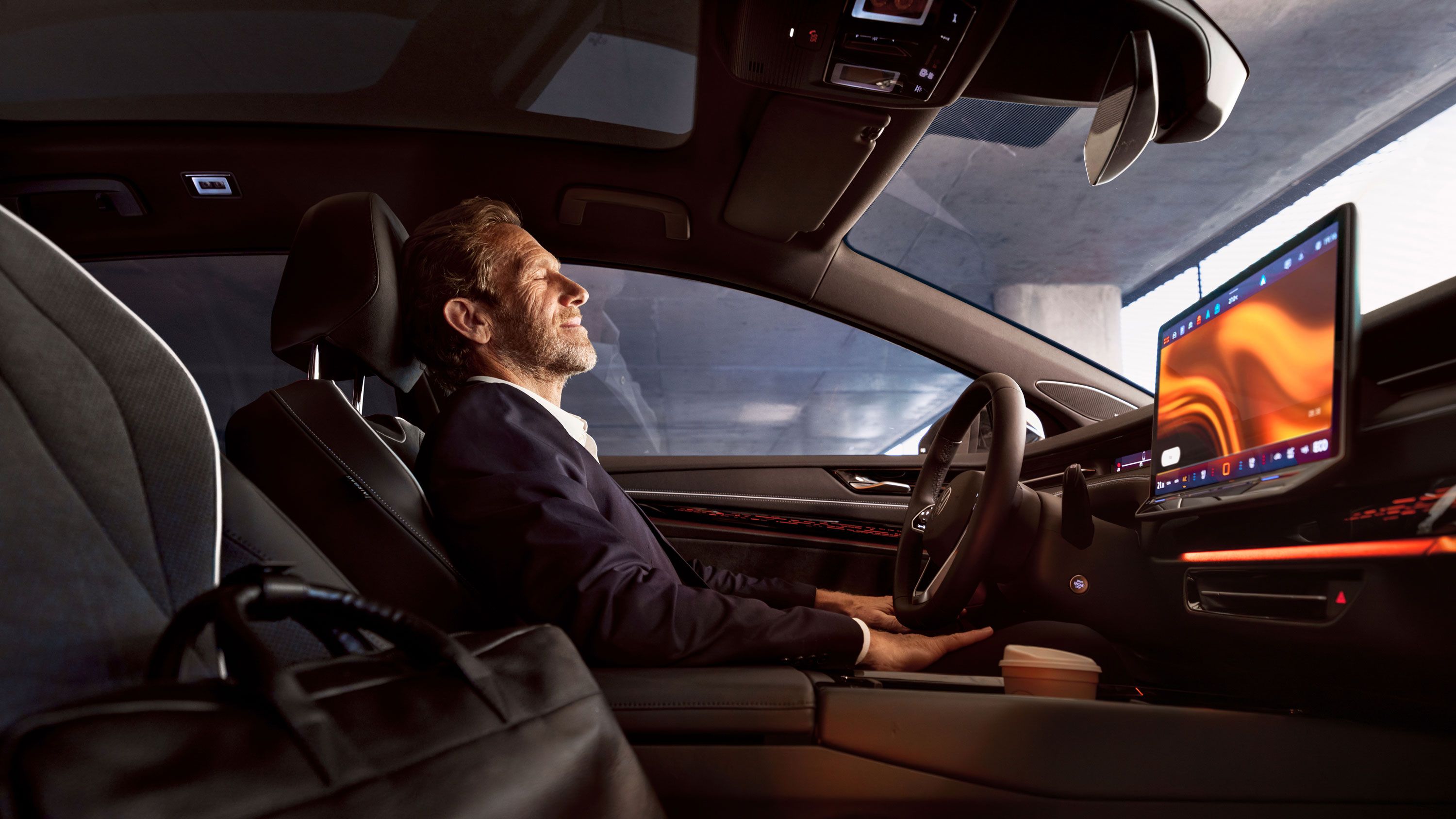 Ein Mann entspannt sich in seinem geparkten VW ID.7